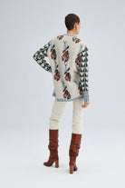 Woman wearing a Fair Isle floral knit sweater with long sleeves and mixed pattern detailing in red, green, and blue.
