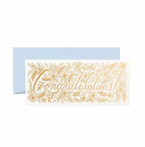A congratulations card with intricate gold floral designs and a light blue envelope.