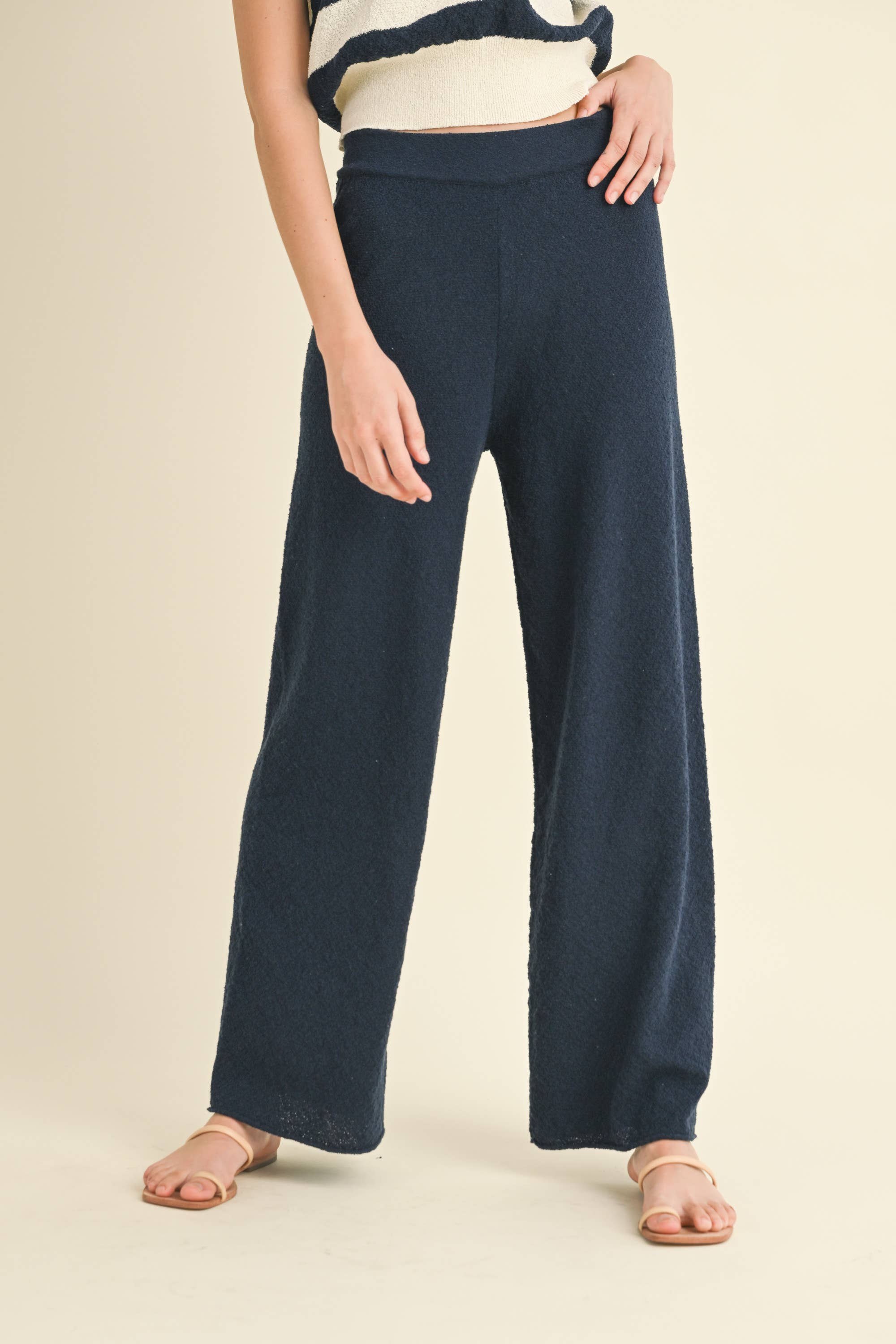 Model wearing navy blue knit wide-leg pants with a relaxed fit and soft texture.