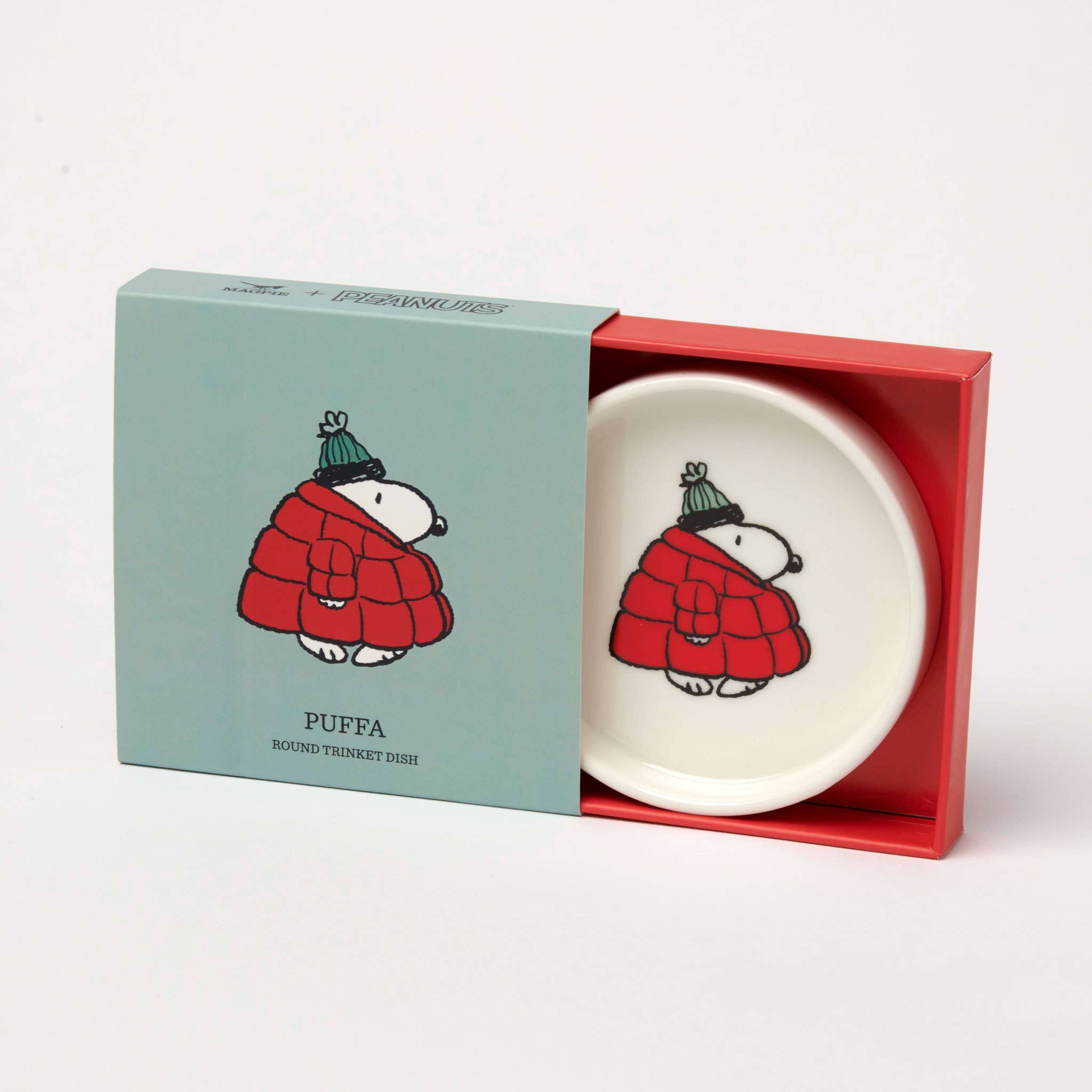 Round ceramic trinket dish featuring a black-and-white beagle wearing a red puffer jacket and green knit hat, packaged in a coordinating gift box.
