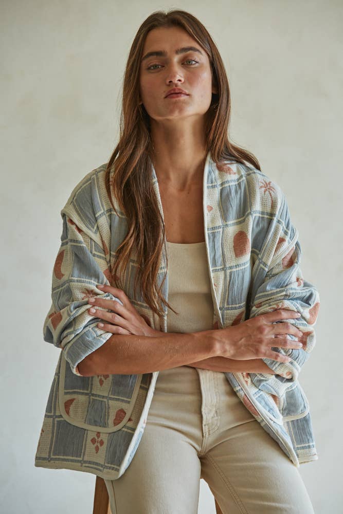 Quilted cotton jacket with desert-themed motifs and soft blue, cream, and terracotta tones