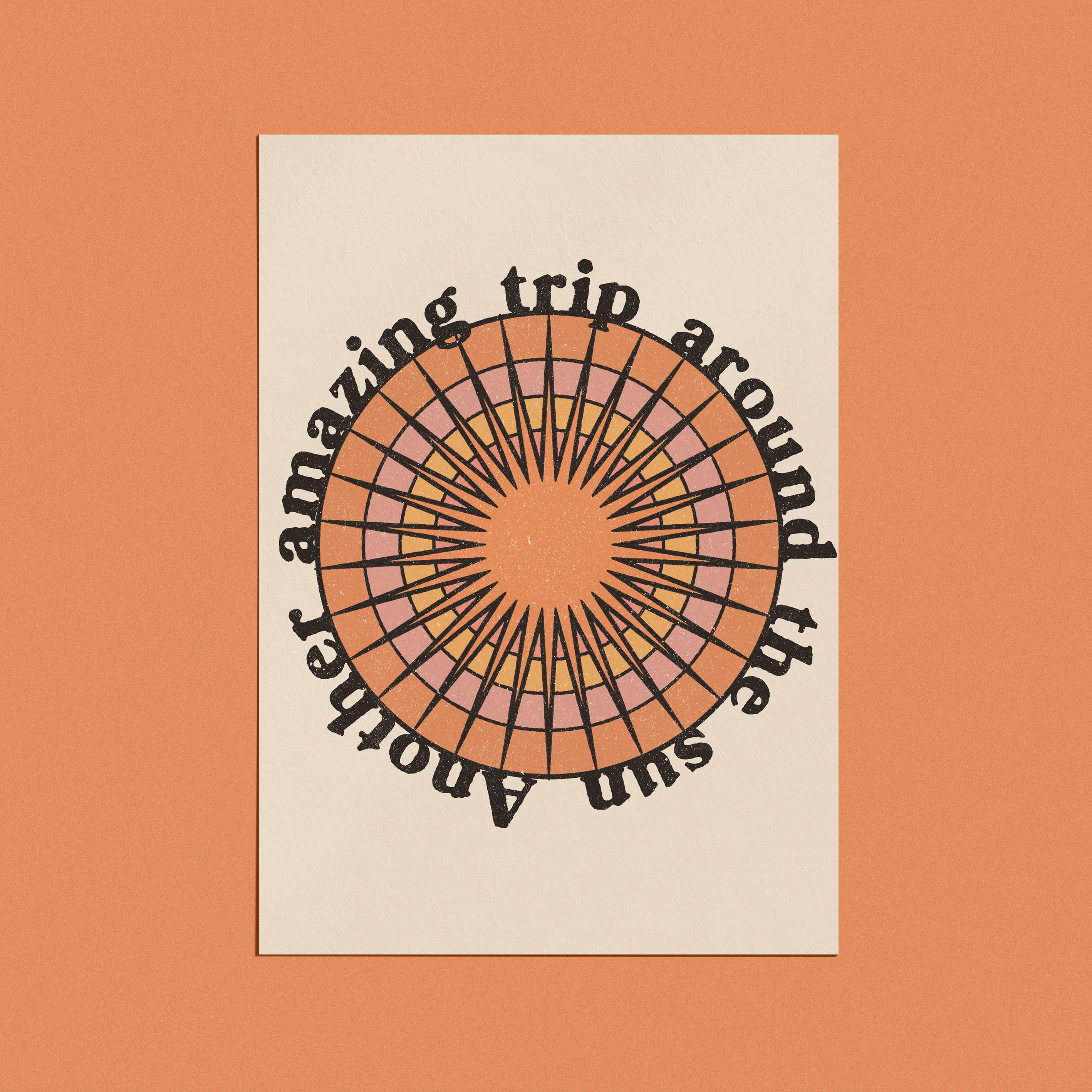 A greeting card with a retro-style sunburst design and the phrase "Another amazing trip around the sun" in bold, circular text.