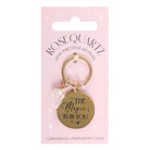 Rose quartz crystal keychain with a gold-tone charm engraved with ‘The Magic Is In You’ text.