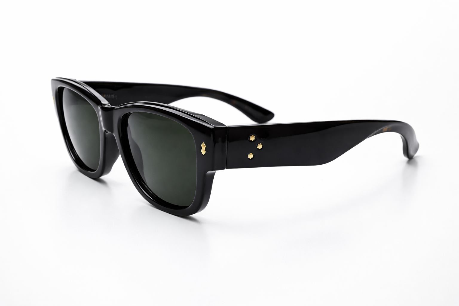 Black sunglasses with gold accents on a white background