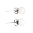 Howlite crystal stud earrings on a matching backing card held by a hand with black nail polish.