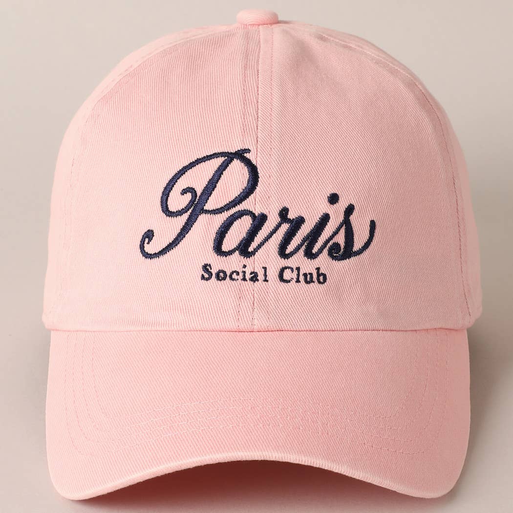 Pink cap with 'Paris Social Club' text on a beige background