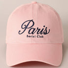 Pink cap with 'Paris Social Club' text on a beige background