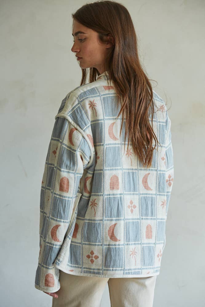 Quilted cotton jacket with desert-themed motifs and soft blue, cream, and terracotta tones