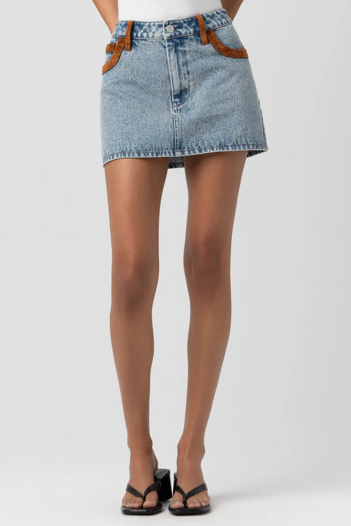 Denim skirt worn by a person on a white background