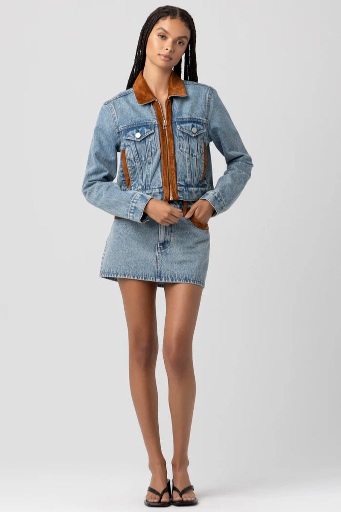 Woman wearing a denim jacket with brown collar on a white background