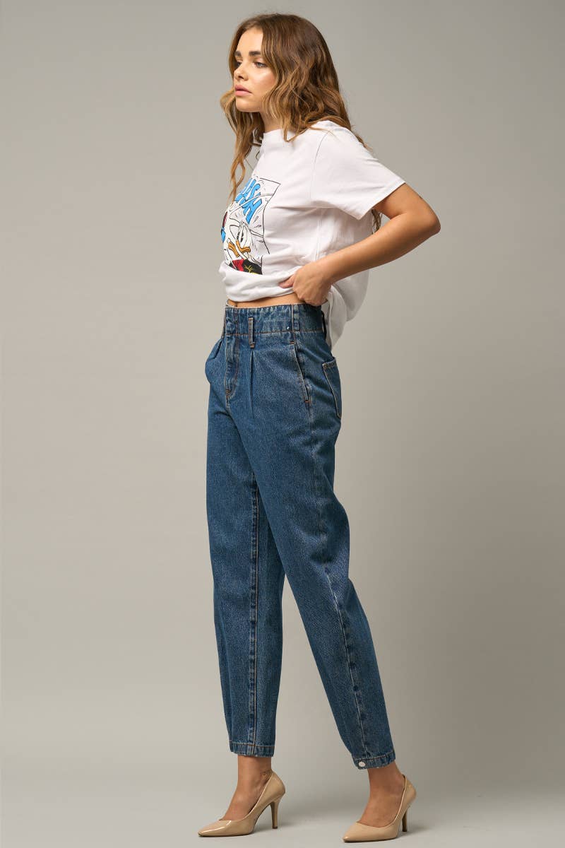 Model wearing high-waist balloon jeans with a relaxed silhouette and slightly tapered legs, paired with a casual graphic t-shirt and neutral heels.