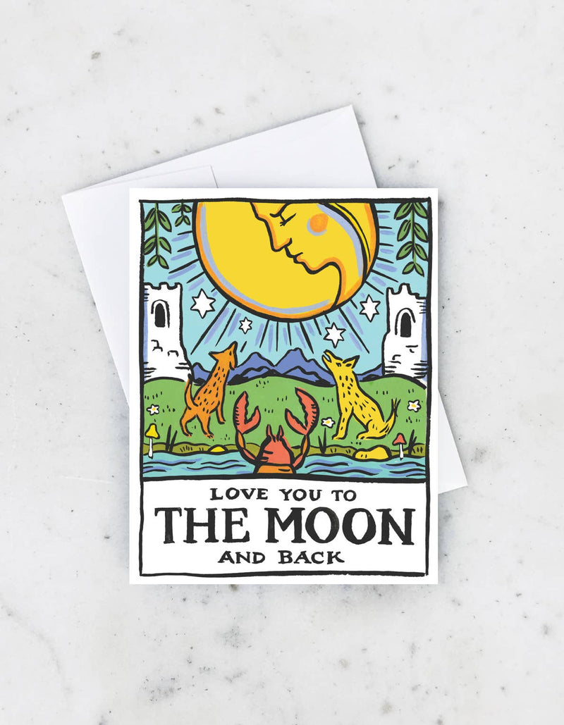A greeting card featuring a hand-painted illustration of the moon and stars with a quote 'Love you to the moon and back'. The card is blank inside and paired with a matching envelope.