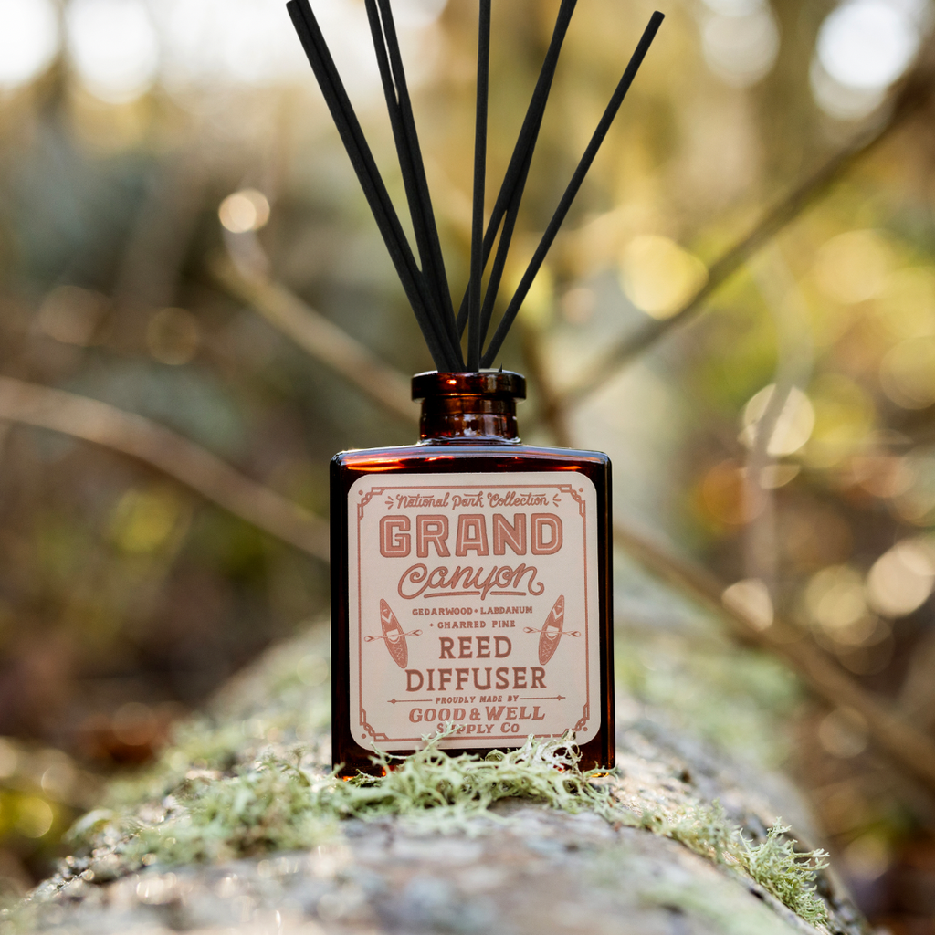 Grand Canyon reed diffuser with amber glass bottle and black reeds by Good & Well Supply Co., scented with cedarwood, labdanum, and charred pine.