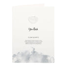 Hand holding a greeting card with a small clear quartz crystal heart and ‘You Rock’ text.