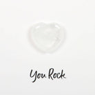 Hand holding a greeting card with a small clear quartz crystal heart and ‘You Rock’ text.