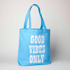 Blue tote bag featuring Snoopy lying on a colorful rainbow, ideal for fans of Peanuts and cheerful accessories.
