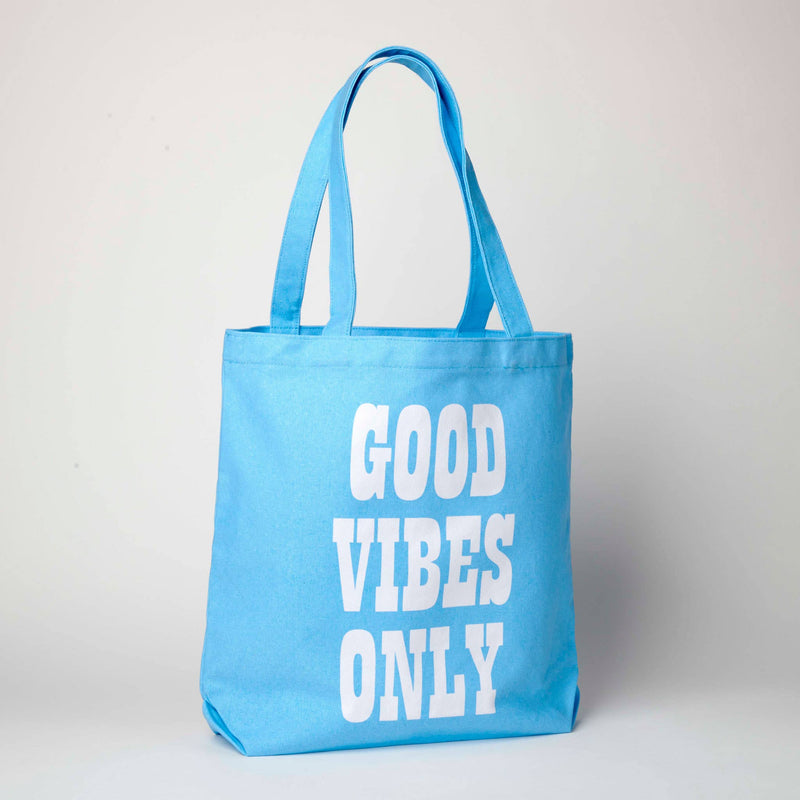 Blue tote bag featuring Snoopy lying on a colorful rainbow, ideal for fans of Peanuts and cheerful accessories.