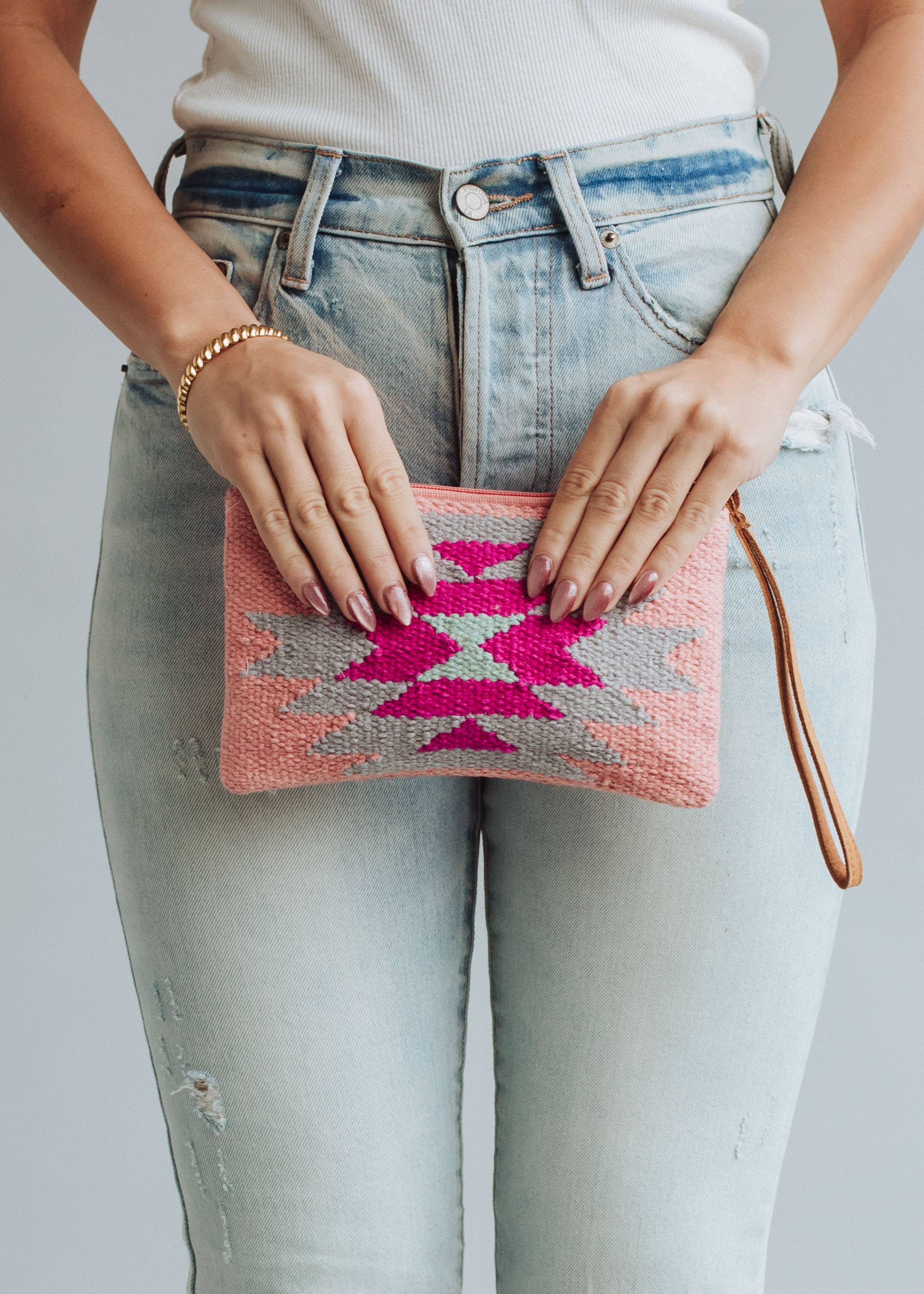 Pastel pink woven wristlet with bold fuchsia, mint, and gray geometric diamond pattern
