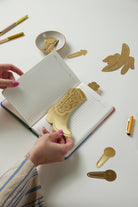 "Celestial" metal page tabs featuring a sun and moon design in brass on a white background.
