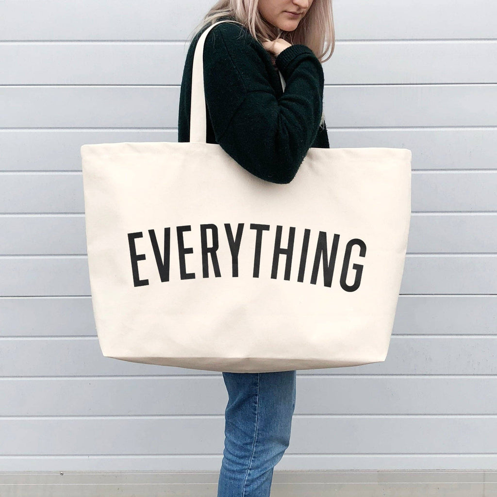 Coral tote bag with “Sunshine Appreciation Society” in white lettering, carried by a woman in a rust-colored embroidered dress