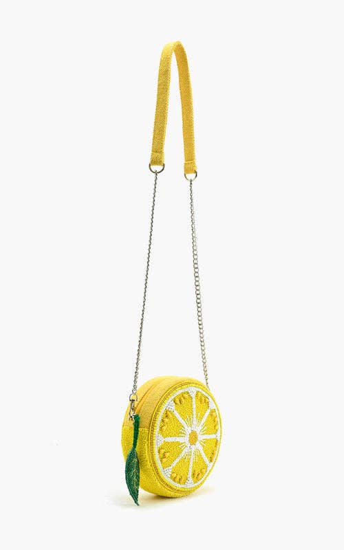 Round beaded lemon slice crossbody bag with silver chain strap and green leaf charm accent.