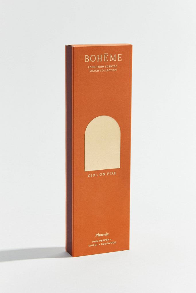 A box of Boheme Phoenix scented matches with a pink and orange design, indicating the scent as 'Girl on Fire' from the Long Form Scented Match Collection.