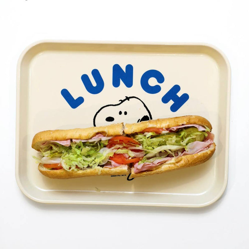 Cream-colored lunch tray featuring Snoopy holding a large sandwich, with the word “LUNCH” in bold blue letters above.
