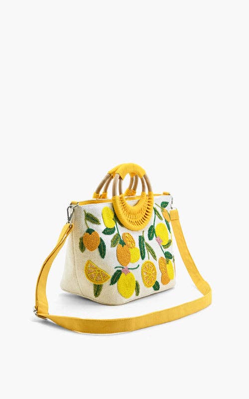 Embroidered handbag with lemons, oranges, and green leaves, featuring a round woven handle and yellow shoulder strap.