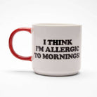 White ceramic mug with a red handle, featuring "I Think I’m Allergic to Mornings!" and a beagle on a red doghouse.