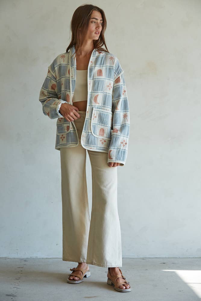 Quilted cotton jacket with desert-themed motifs and soft blue, cream, and terracotta tones
