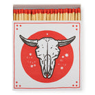  A square matchbox adorned with a saint motif, featuring no skull iconography.