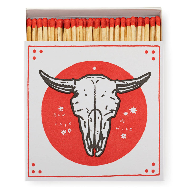  A square matchbox adorned with a saint motif, featuring no skull iconography.