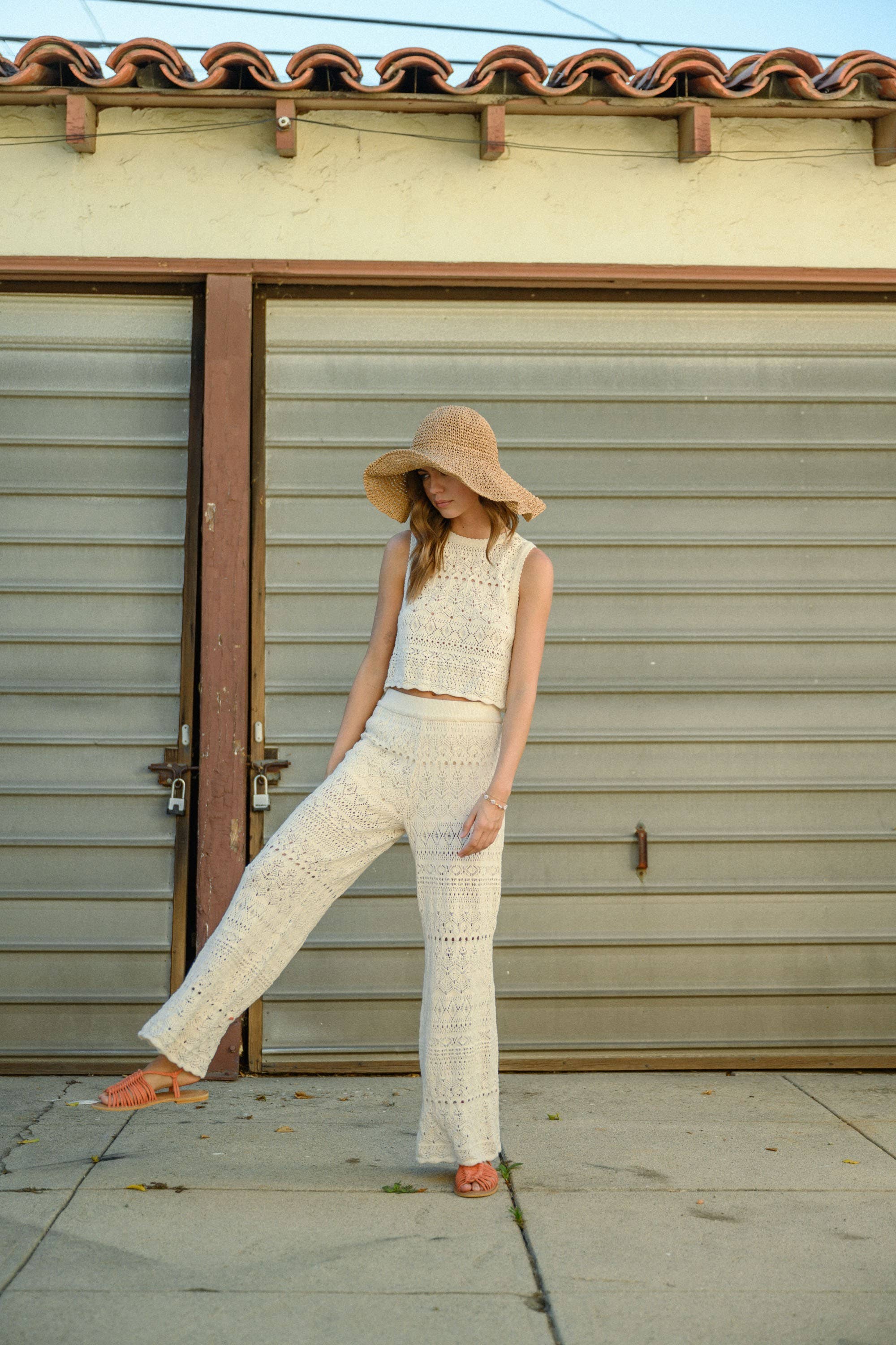 Model wearing cream-colored crochet wide-leg pants with intricate patterns and a high waist.