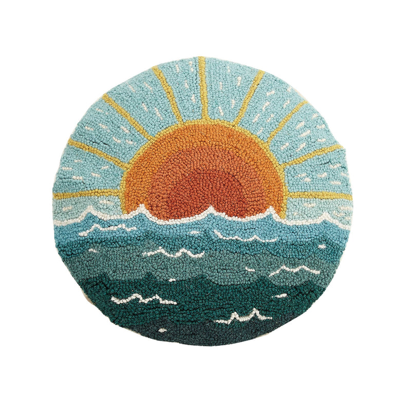 Round cushion with a hand-hooked sunrise over the ocean design in coastal colors.