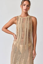 Woman wearing a sleeveless ladder knit midi dress.