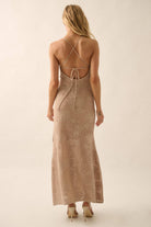 Woman wearing a sheer white lace maxi dress with spaghetti straps and floral detailing.