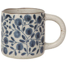 A beige ceramic mug with blue floral patterns.