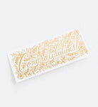 A congratulations card with intricate gold floral designs and a light blue envelope.