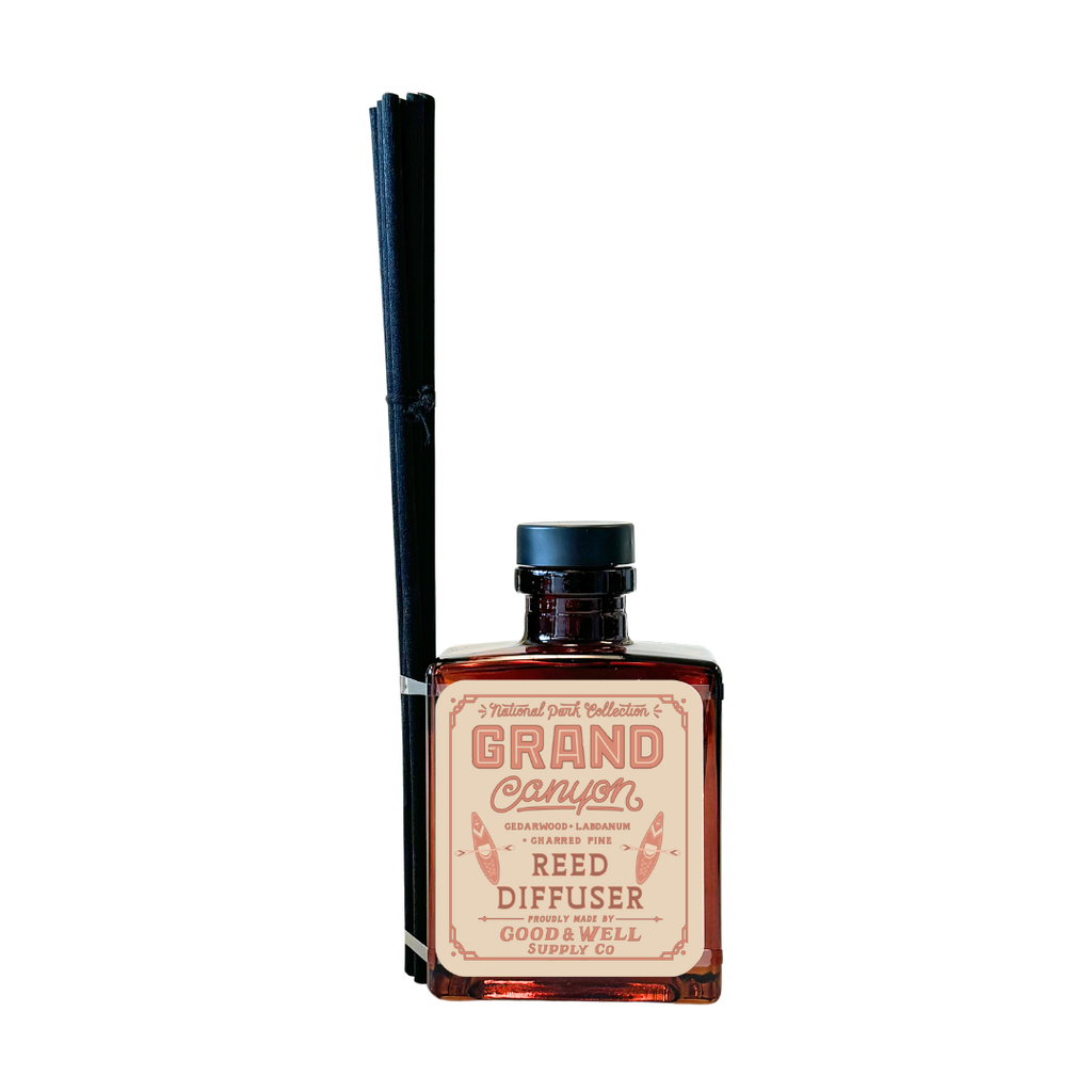 Grand Canyon reed diffuser with amber glass bottle and black reeds by Good & Well Supply Co., scented with cedarwood, labdanum, and charred pine.