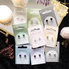 Howlite crystal stud earrings on a matching backing card held by a hand with black nail polish.