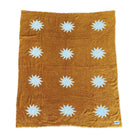 Cozy plush throw blanket in buckhorn brown with a white sunburst pattern, draped over a leather couch in a stylish and inviting living room.