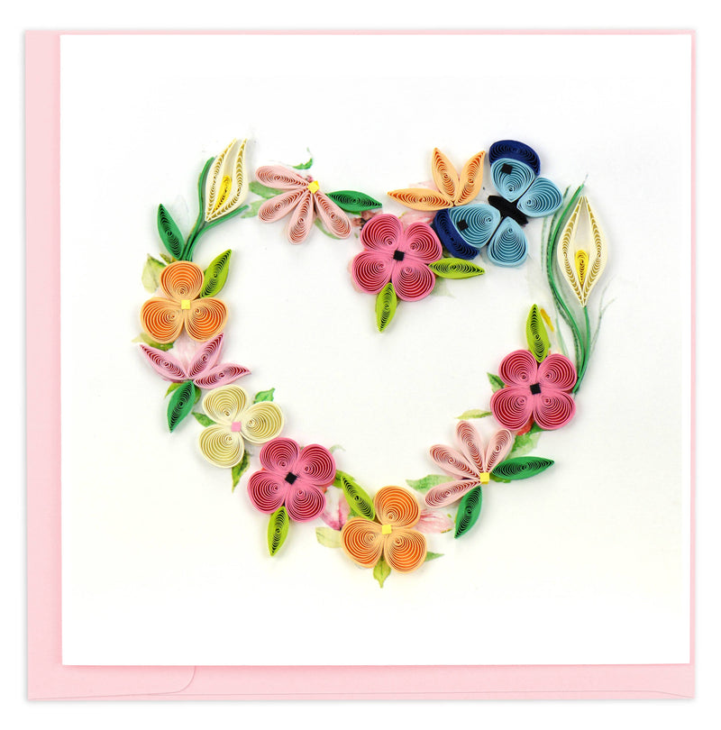 Quilled floral design in the shape of a heart on a pink background