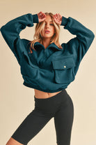 Woman wearing an oversized teal fleece pullover with a quarter zip and black leggings; Woman in a beige fleece pullover with a quarter zip and denim shorts.