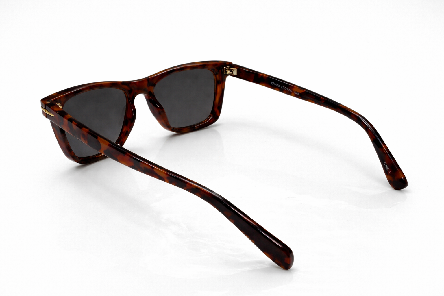 Sunglasses with tortoiseshell frame and dark lenses on a white background