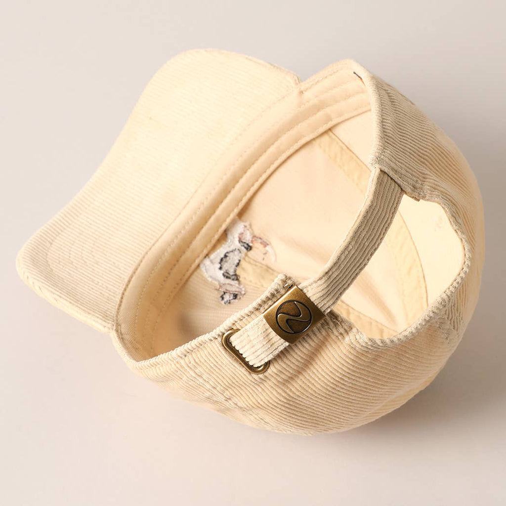 Beige corduroy baseball cap with embroidered beagle dog design on the front.