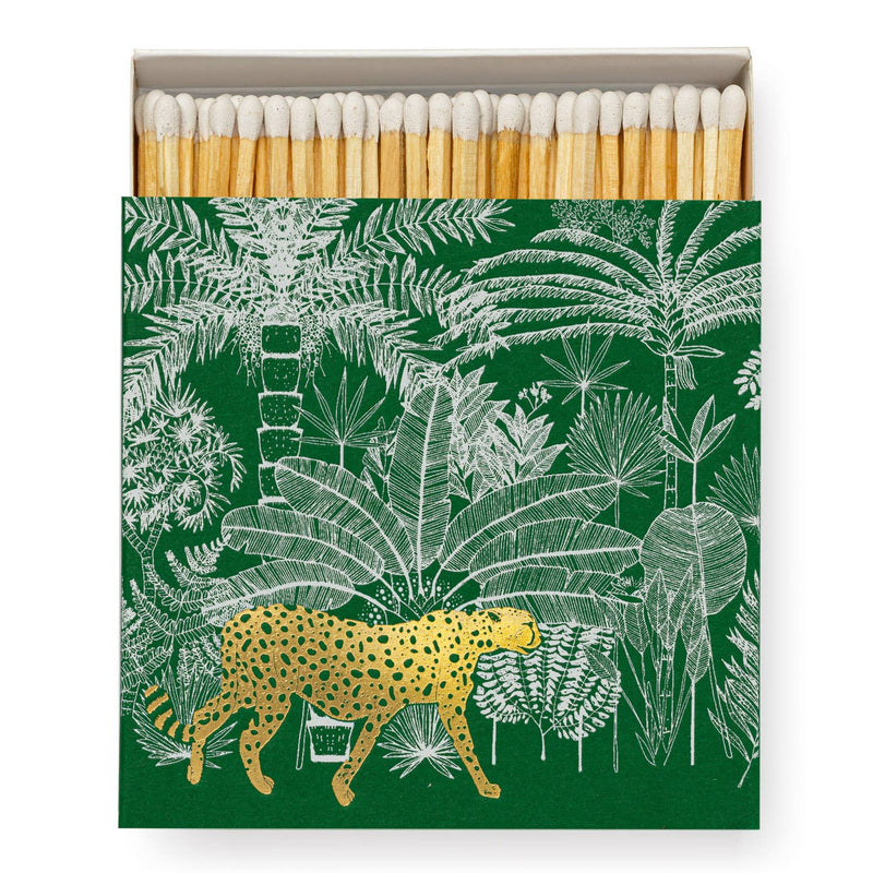 A square matchbox adorned with a cheetah amidst lush jungle foliage.