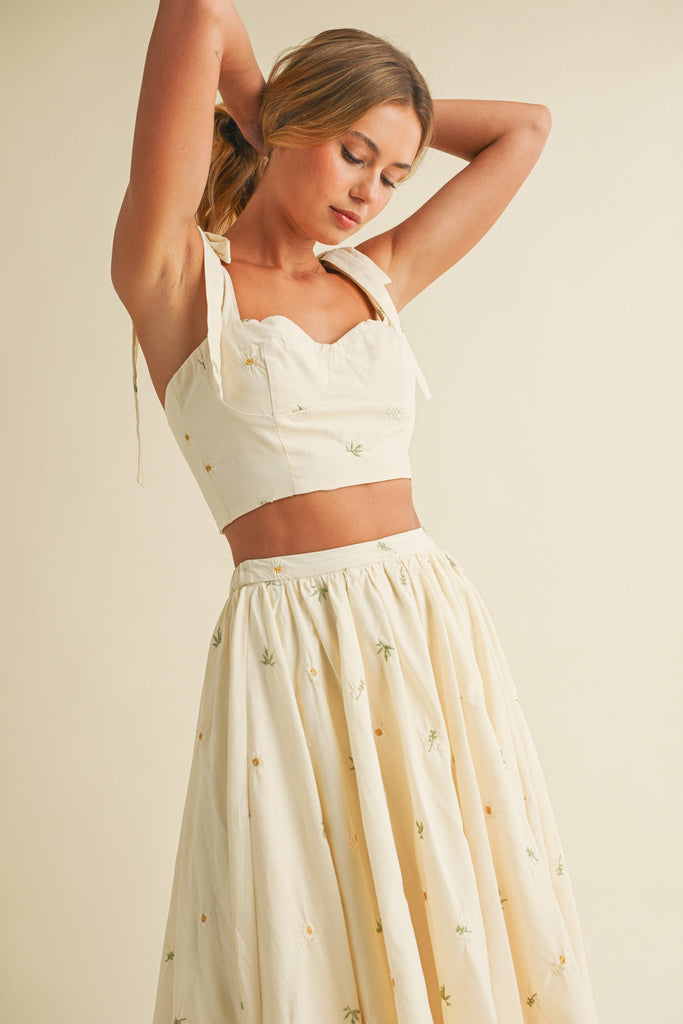 Light cream two-piece set with small floral embroidery, featuring bow-tie strap top and flowy maxi skirt