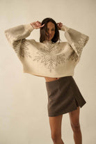 Oversized cream sweater with grey snowflake design.