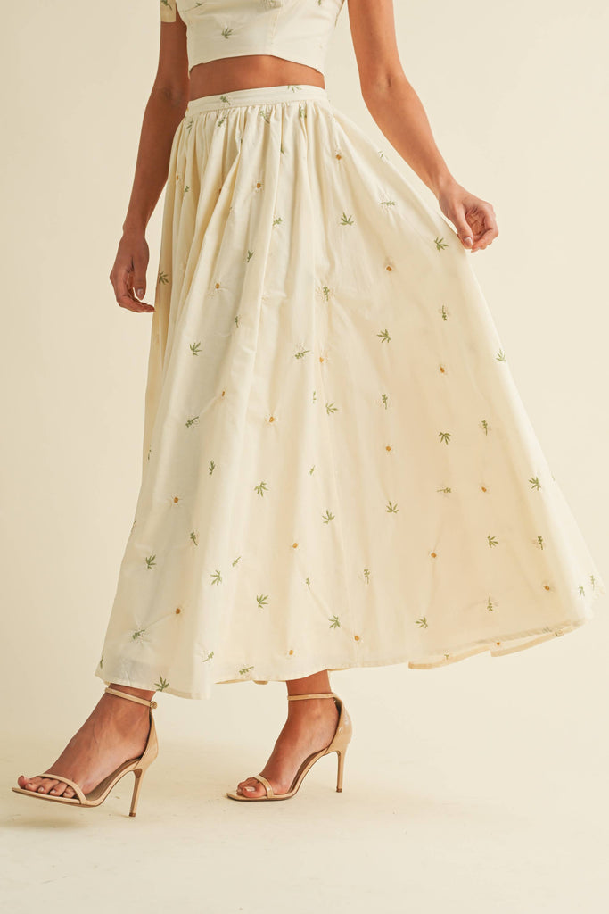 Light cream two-piece set with small floral embroidery, featuring bow-tie strap top and flowy maxi skirt