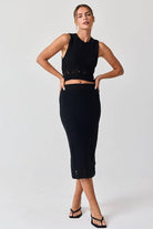 Woman wearing a black sleeveless crochet top and midi skirt set.